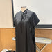 A black short-sleeve dress displayed on a mannequin torso or a Dress Form. The dress has a high collar with tie details at the front and side.