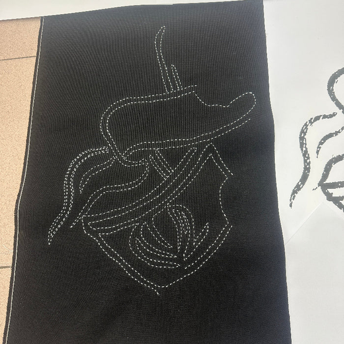 A black fabric with a white Sashiko Stitches outline showing the matching sketch on the paper.
Done by BabyLock Sashiko BLQK Sewing Machine | Traditional Japanese Hand Stitch Machine. 
